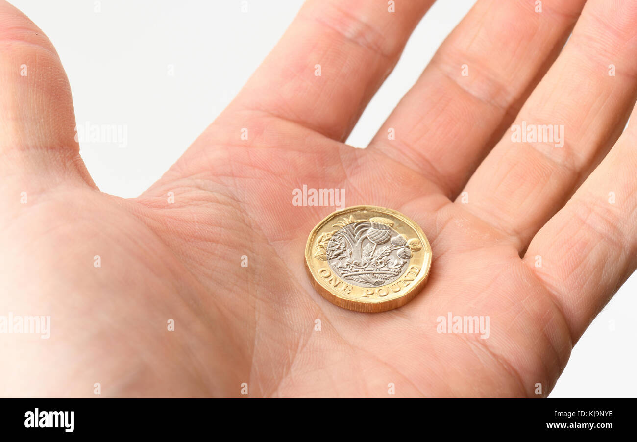 A hand open offering a pound coin Stock Photo