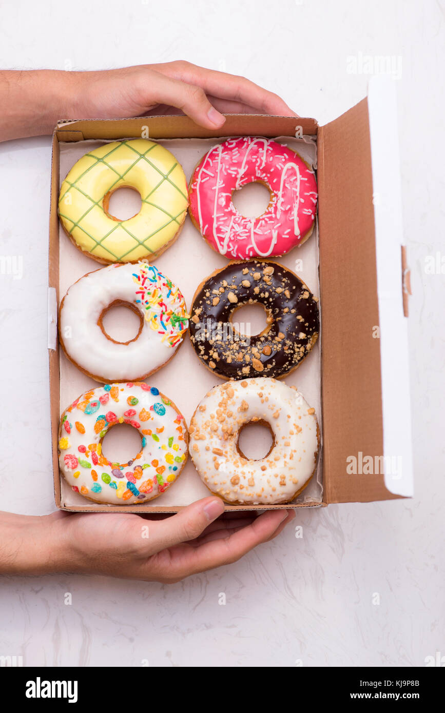 Colored donuts with glaze. Assorted doughnuts with different fillings in the box Stock Photo