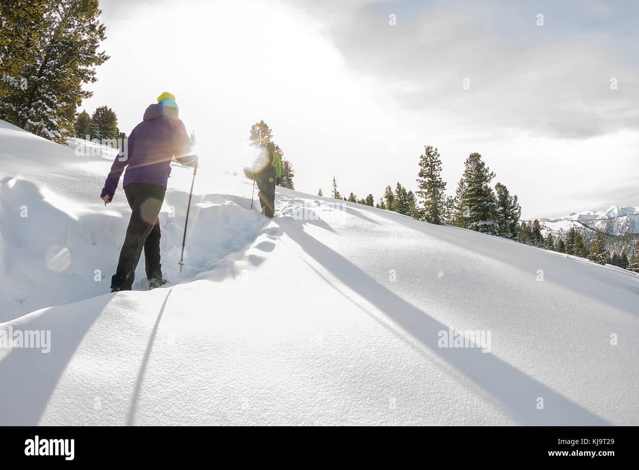 two happy women traveler with backpacks walking in winter mountains ...