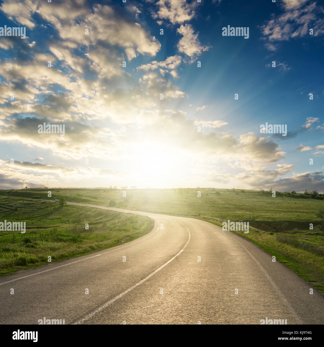 sunset in clouds over asphalt road to horizon Stock Photo - Alamy