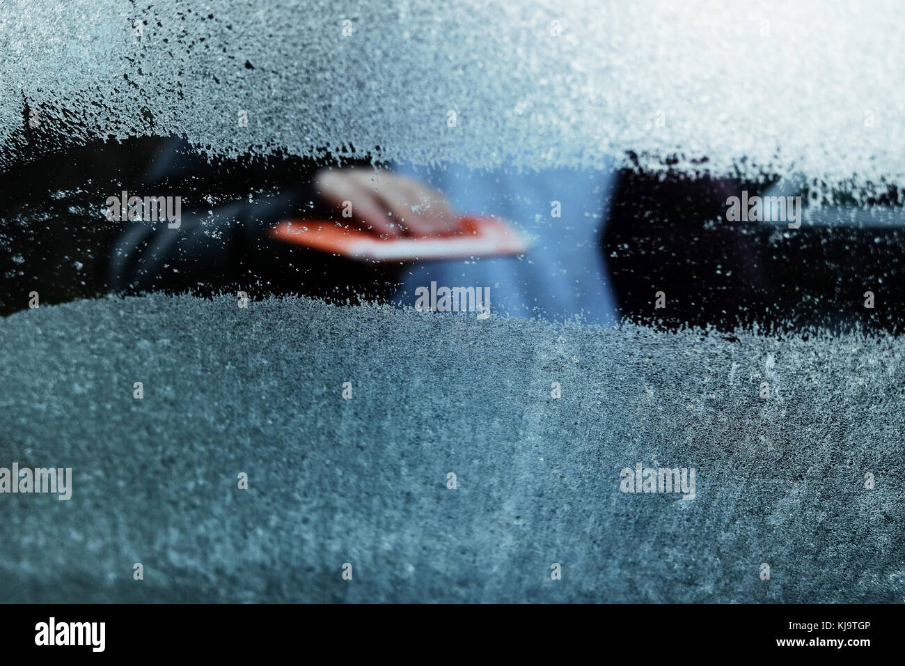 Scraping a car window of ice on a frosty morning Stock Photo
