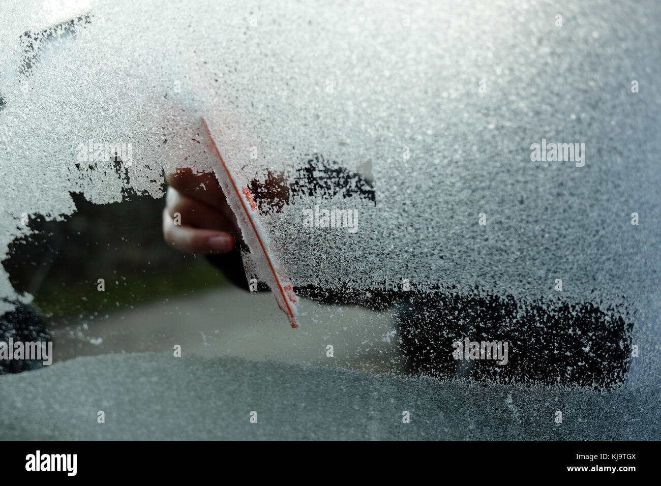 Scraping a car window of ice on a frosty morning Stock Photo Alamy