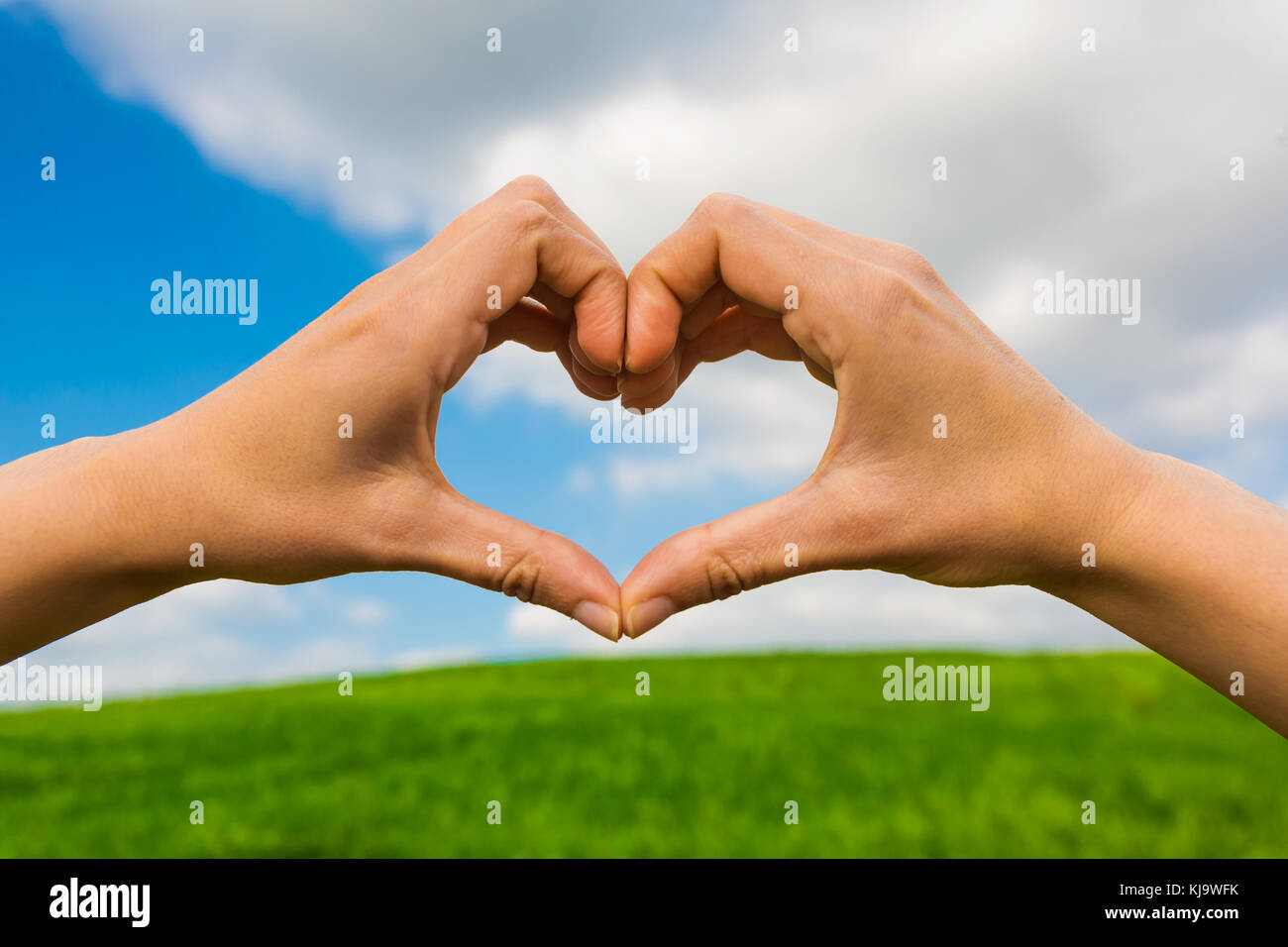 Female hand making a heart shape against a beautiful blue sky Stock ...