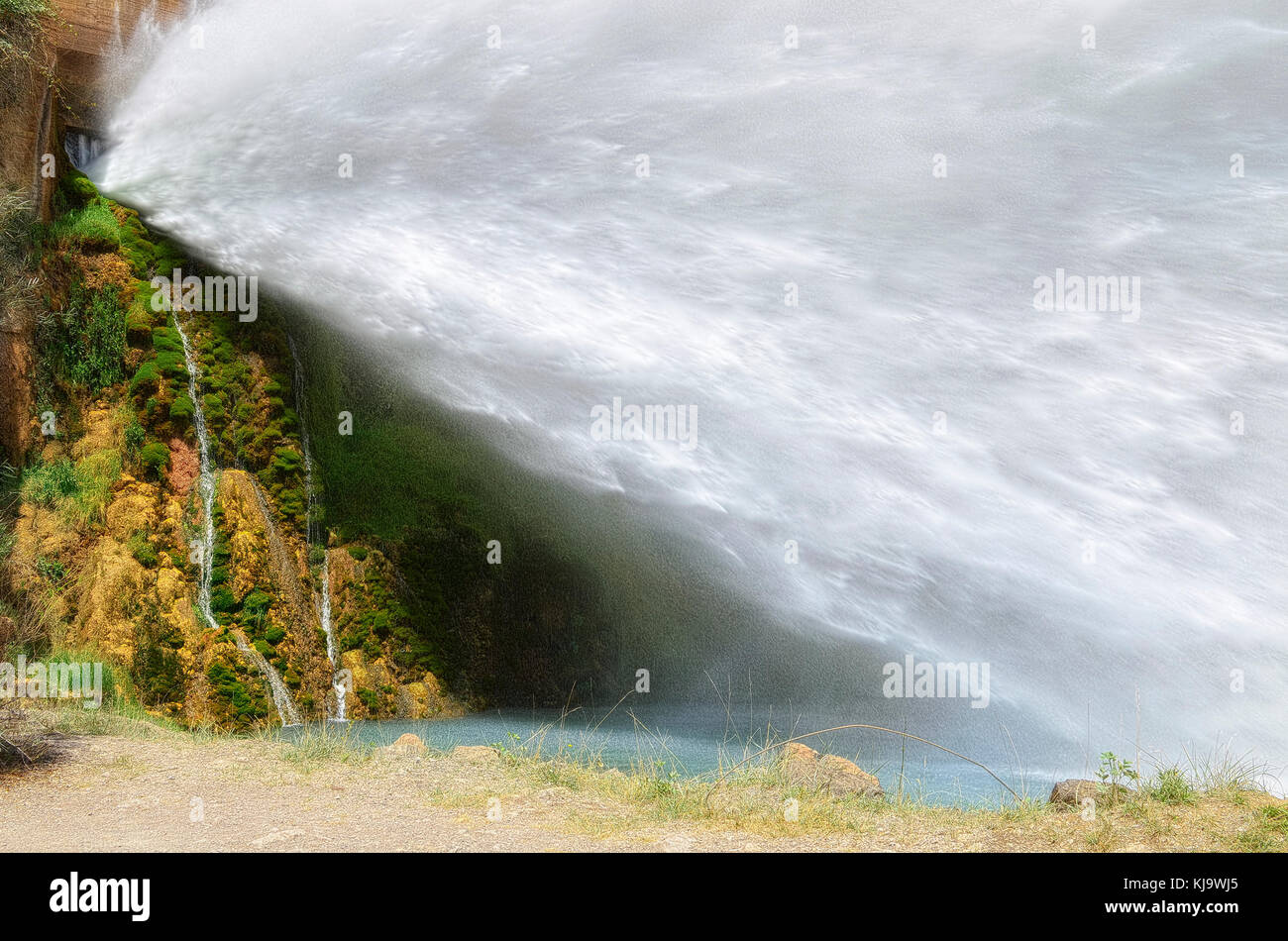 Atomized water from spillway of Arenos reservoir, in Montanejos (Castellon - Spain). Amazing scene. Water going out with very pressure. Sunny day. Stock Photo