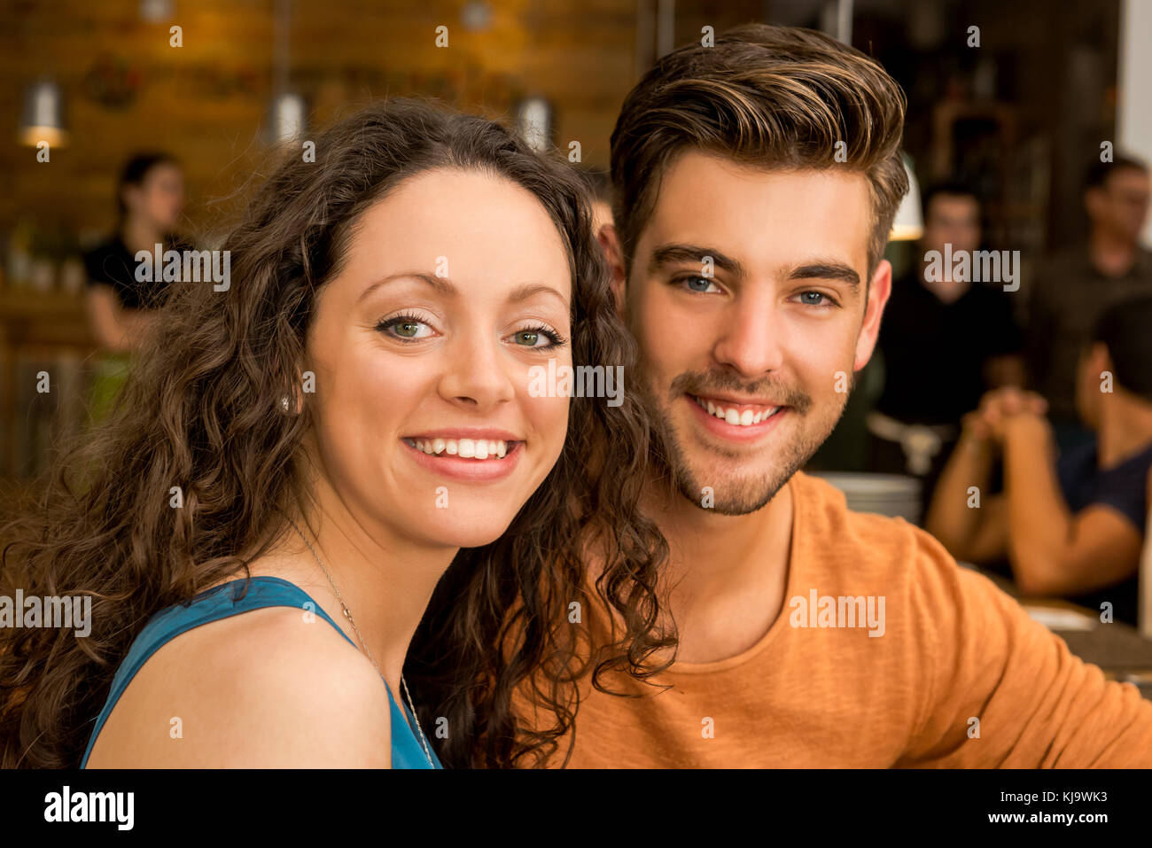 Happy couple at the restaurant talking and smiling Stock Photo