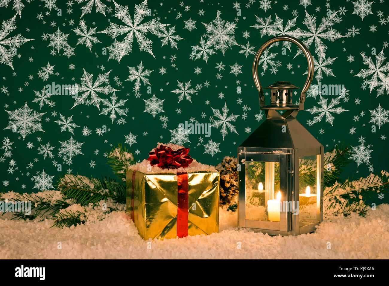 Christmas lantern still life with a gift wrapped present and snowflakes. Stock Photo