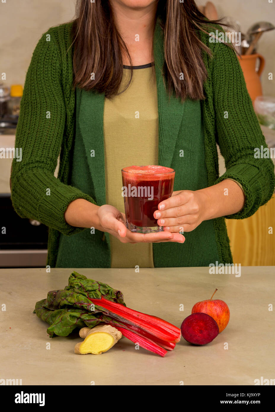 Woman holding a glass of red juice. Preparing a detox juice. Stock Photo