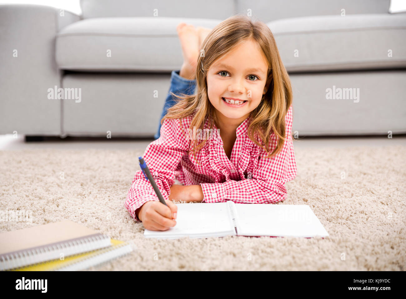 Cute little girl at home studying Stock Photo - Alamy