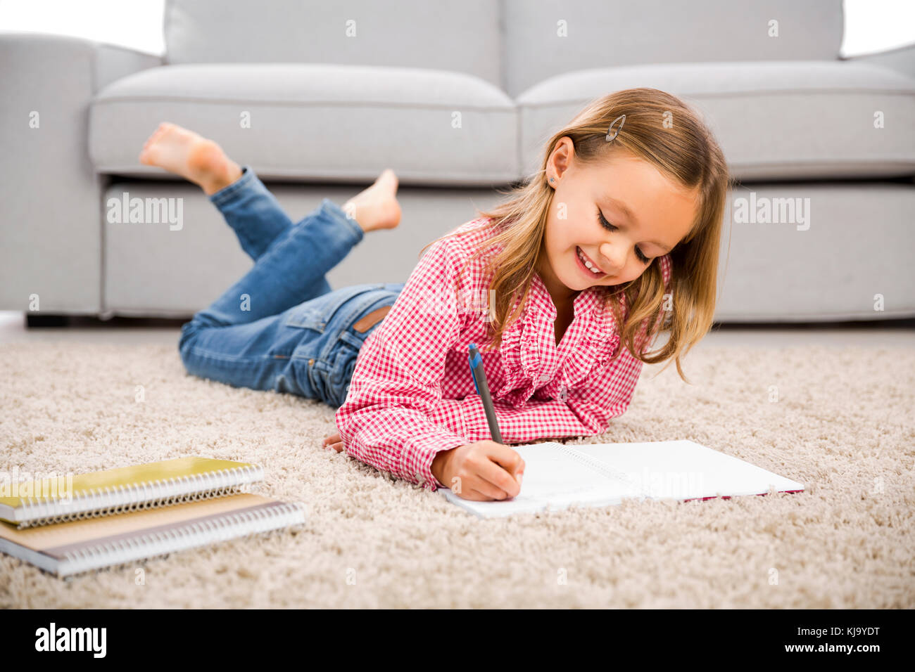 Cute little girl at home studying Stock Photo - Alamy