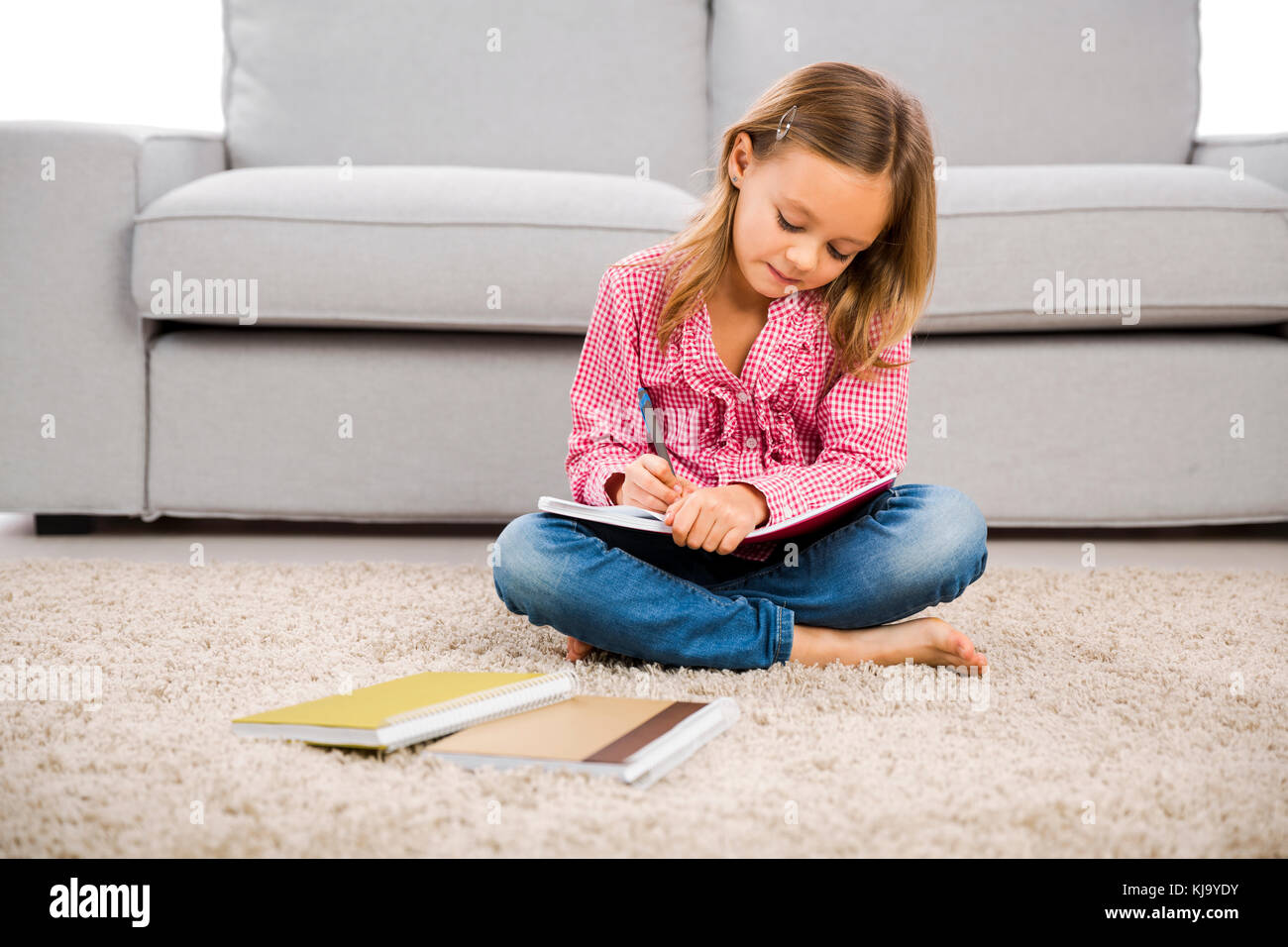 Cute little girl at home studying Stock Photo - Alamy