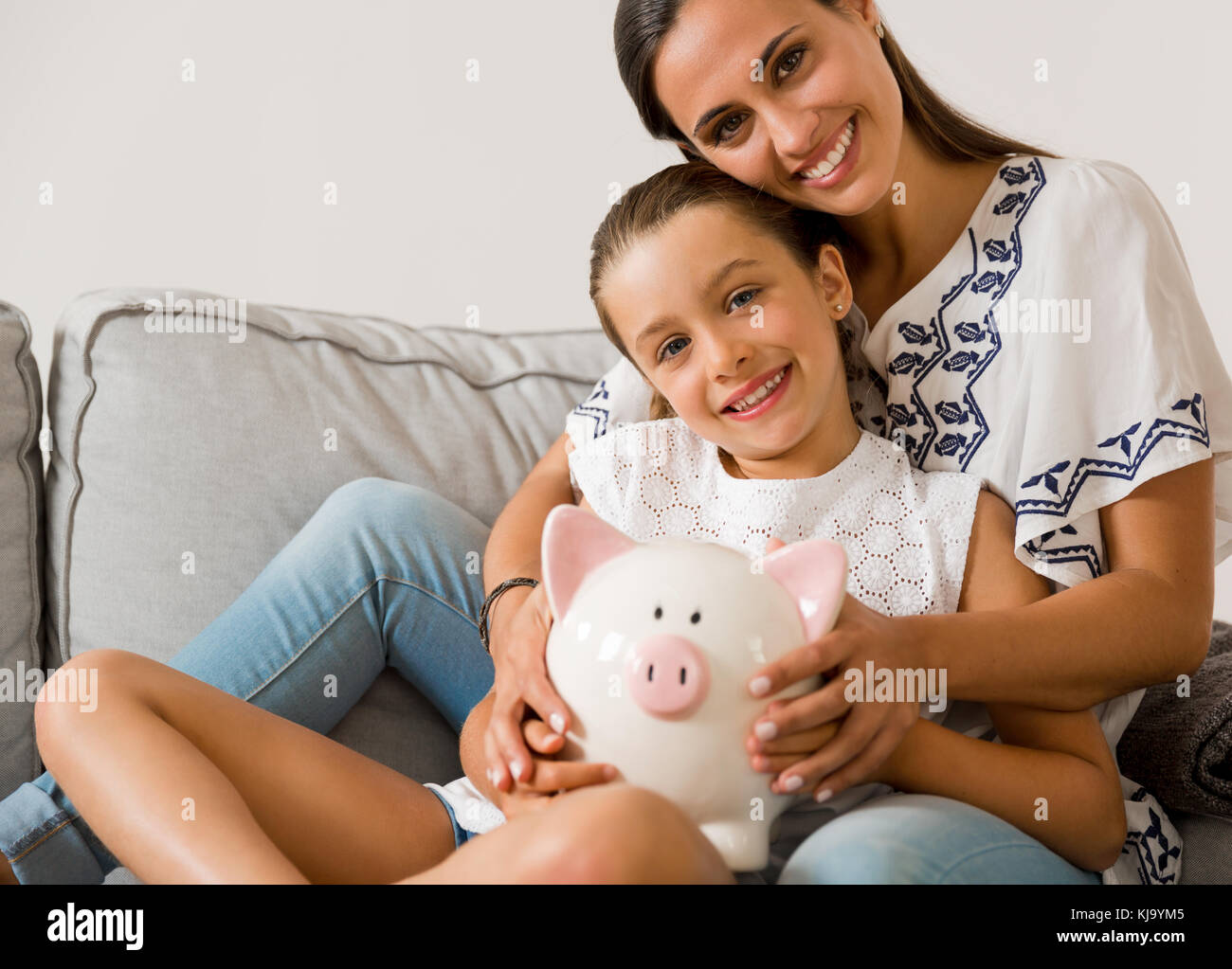 Mother and daughter with a piggy bank for her future savings Stock ...