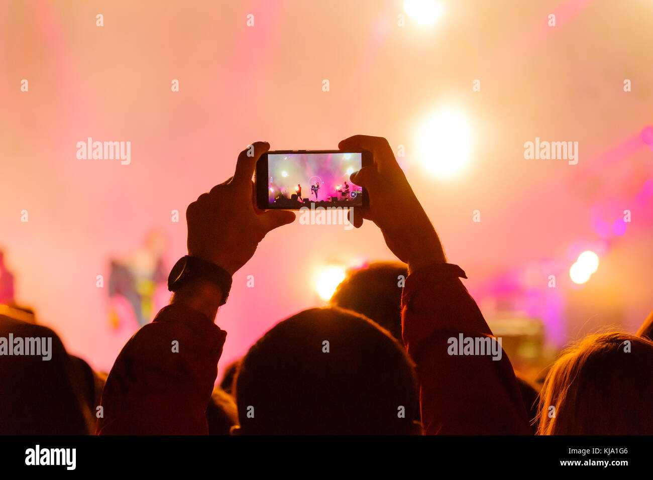 Concert visitor shoots video Stock Photo