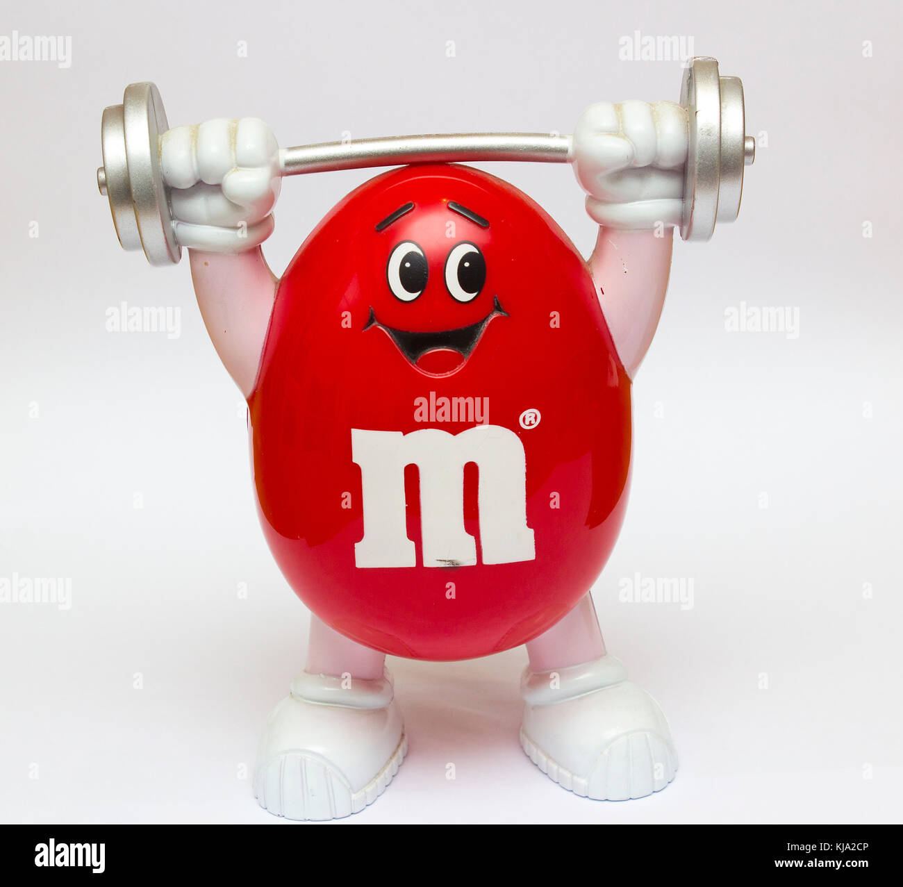 A Plastic moulded novelty M&M  community sweet container in a red weight lifter cartoon style Stock Photo