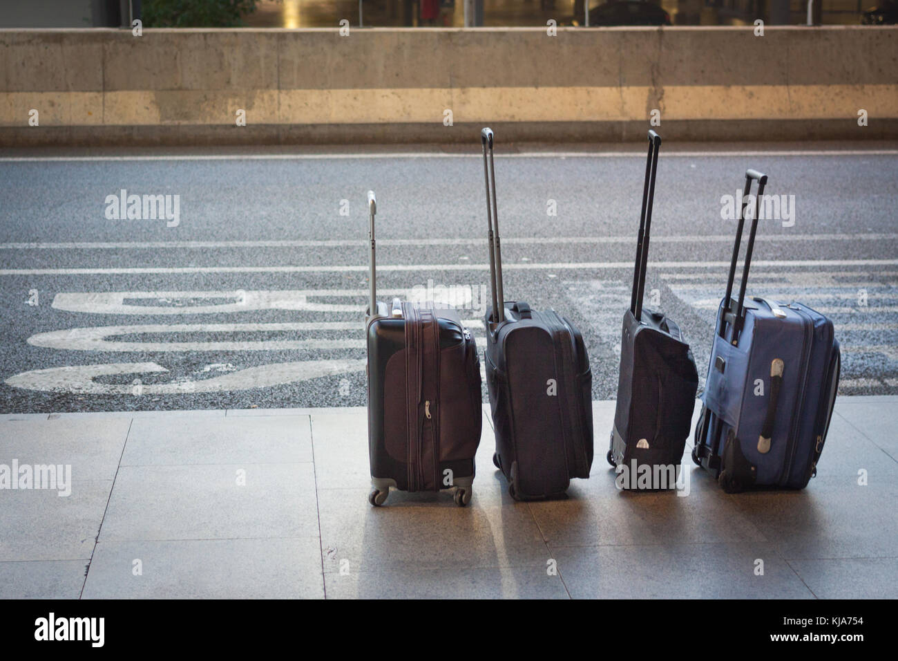 Four suitcases in a line at the airport. Travelling concept Stock Photo