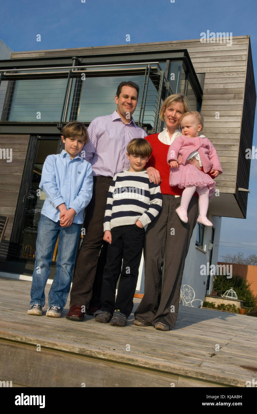 Family standing front of their home Stock Photo - Alamy
