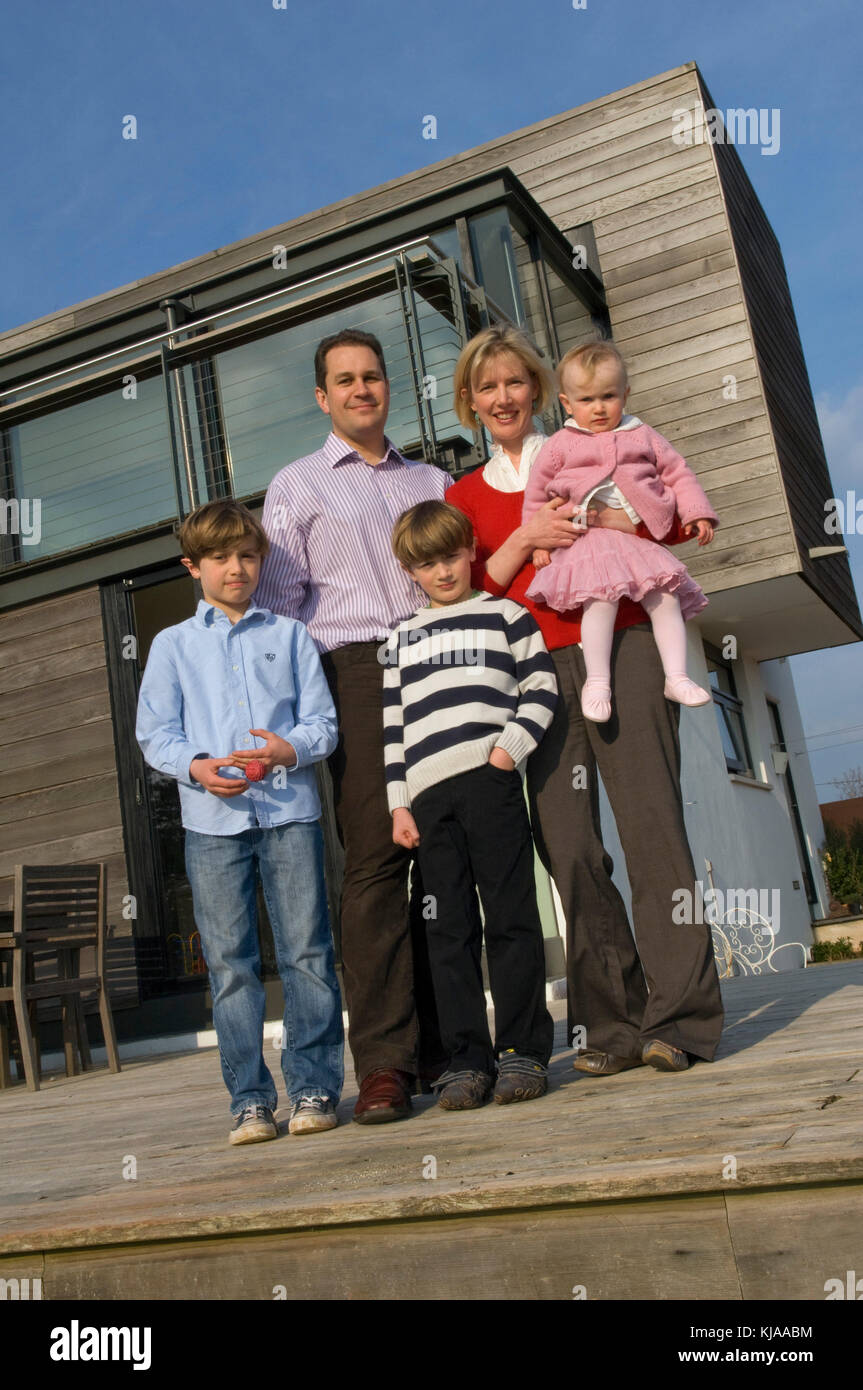 Family standing front of their home Stock Photo - Alamy