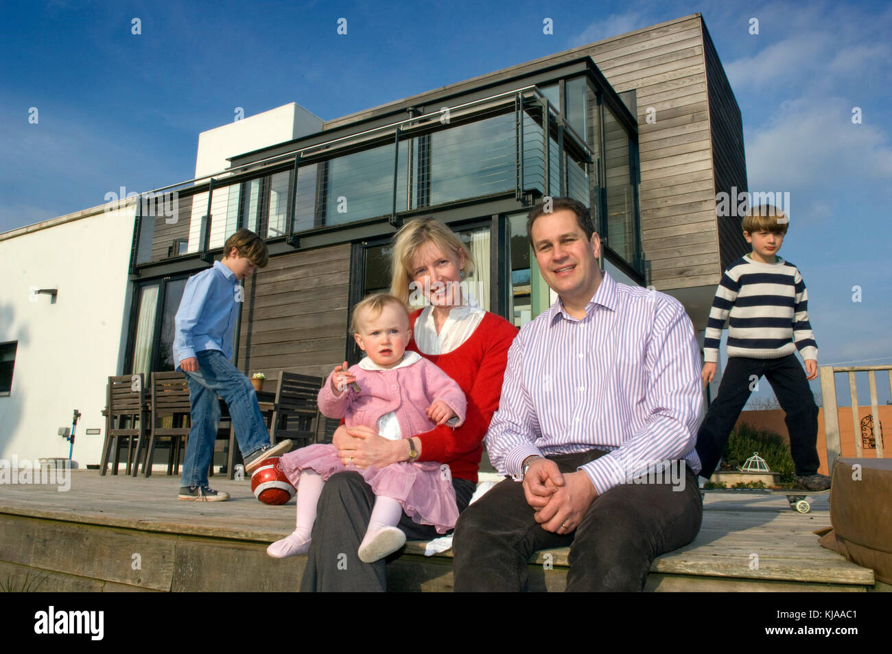 Family standing front of their home Stock Photo - Alamy