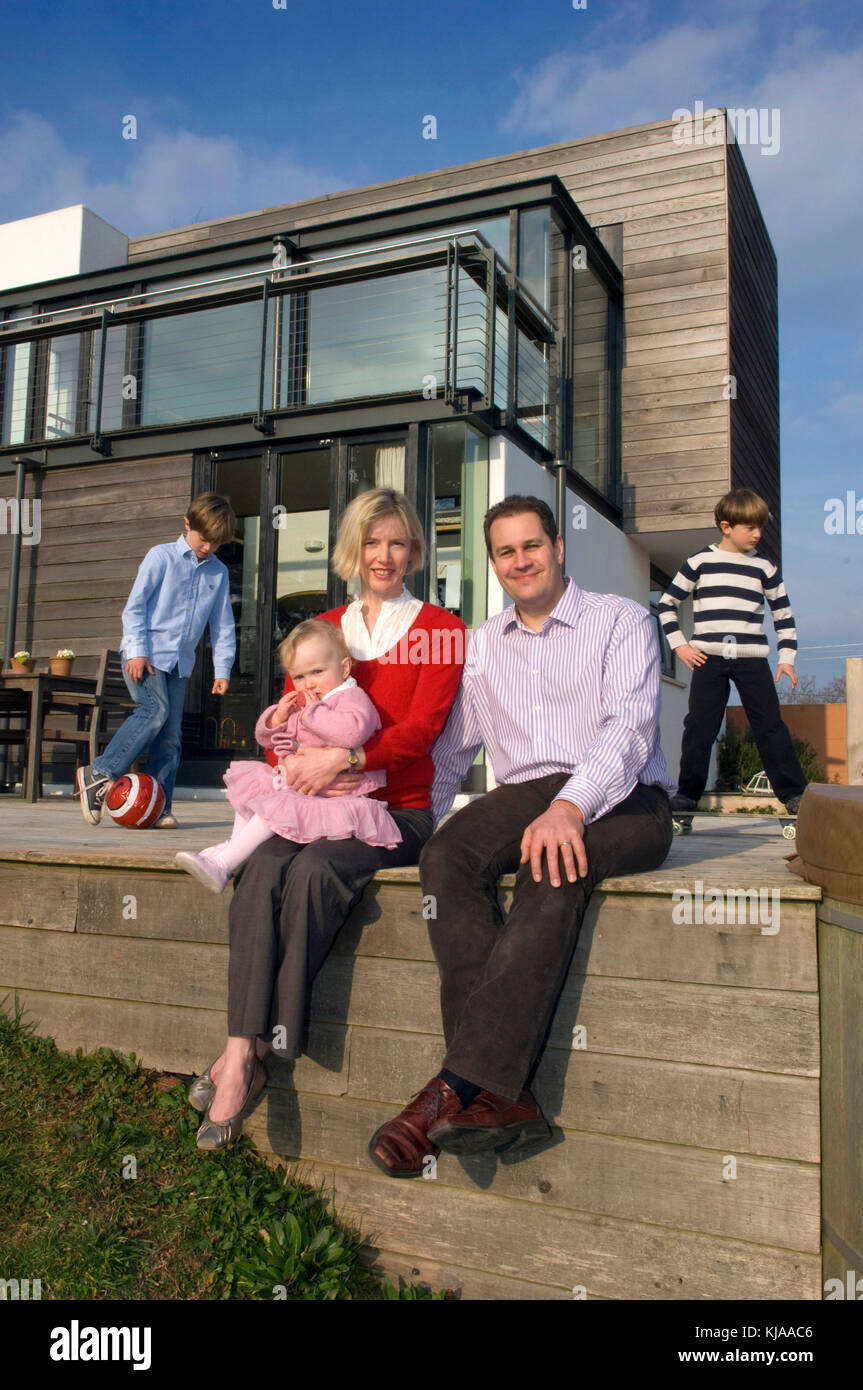 Family standing front of their home Stock Photo - Alamy