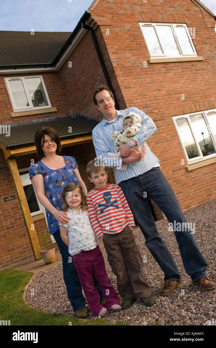 Family standing front of their home Stock Photo - Alamy