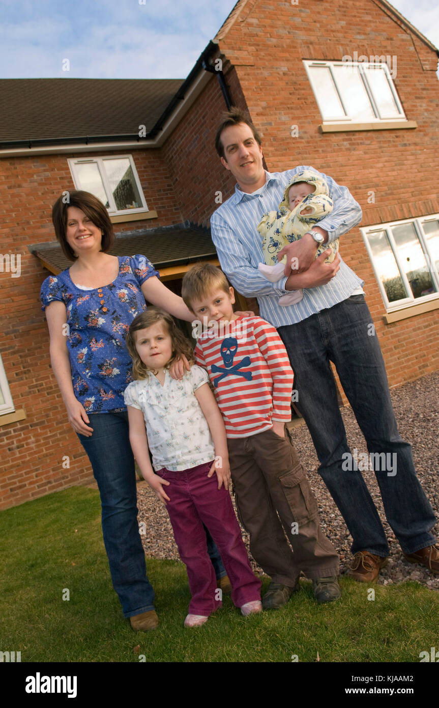 Family standing front of their home Stock Photo - Alamy