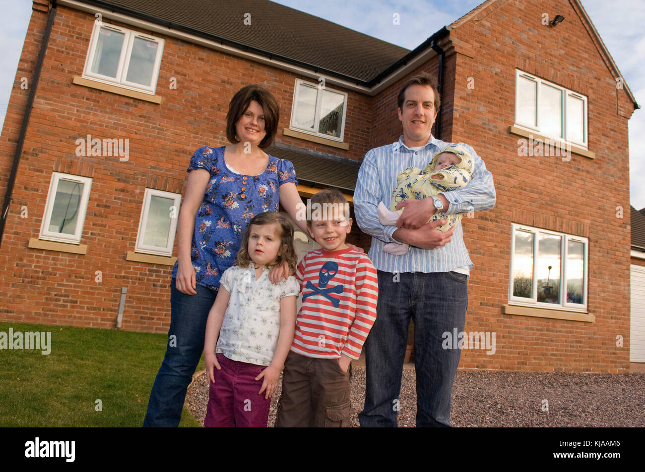 Family standing front of their home Stock Photo - Alamy