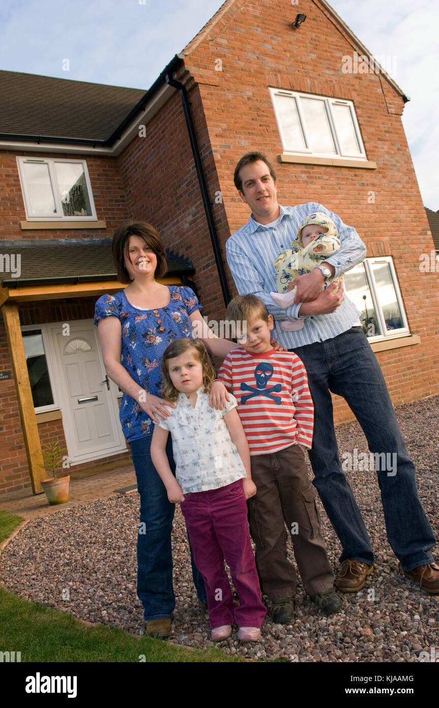 Family standing front of their home Stock Photo - Alamy