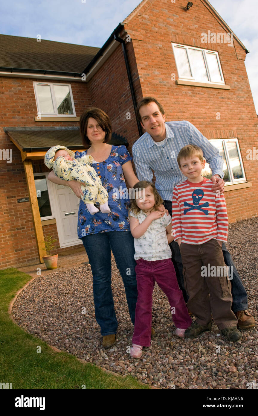 Family standing front of their home Stock Photo - Alamy
