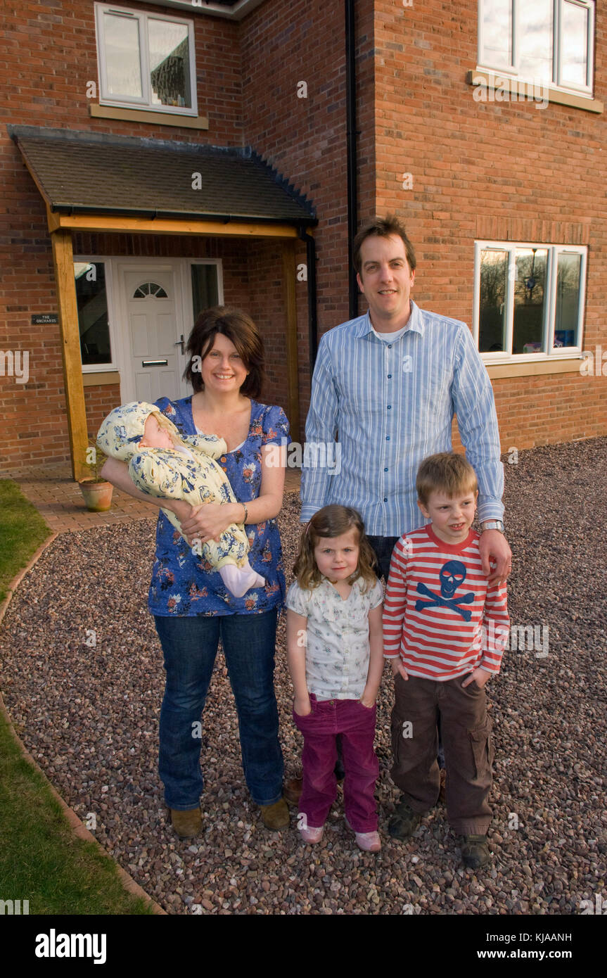 Family standing front of their home Stock Photo - Alamy