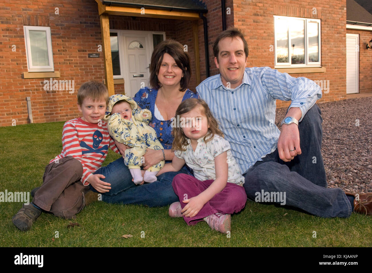 Family standing front of their home Stock Photo - Alamy