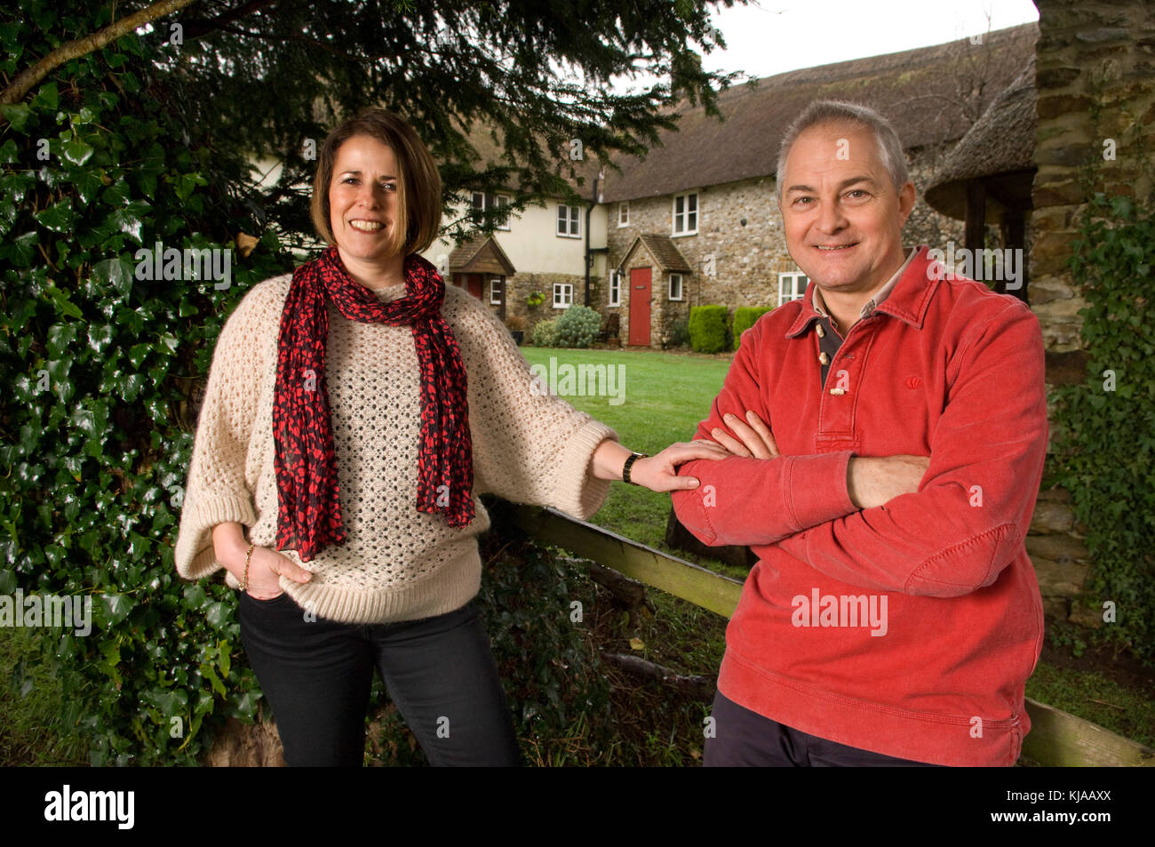 Couple standing front of their home Stock Photo - Alamy