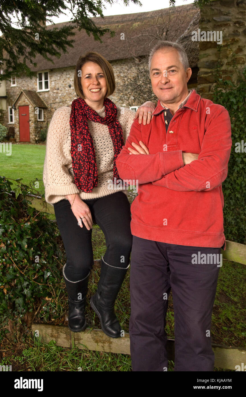 Couple standing front of their home Stock Photo - Alamy