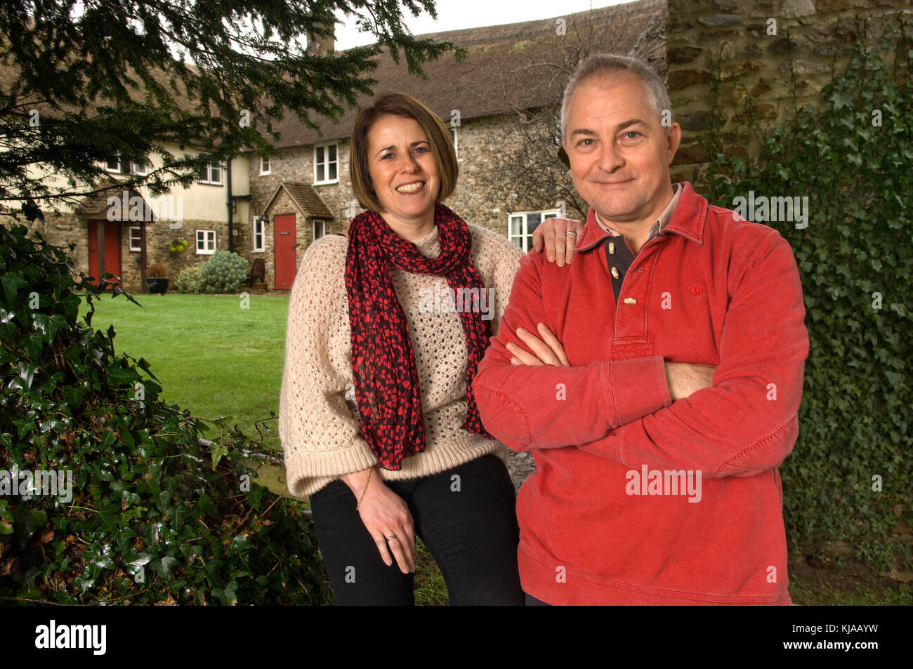 Couple standing front of their home Stock Photo - Alamy