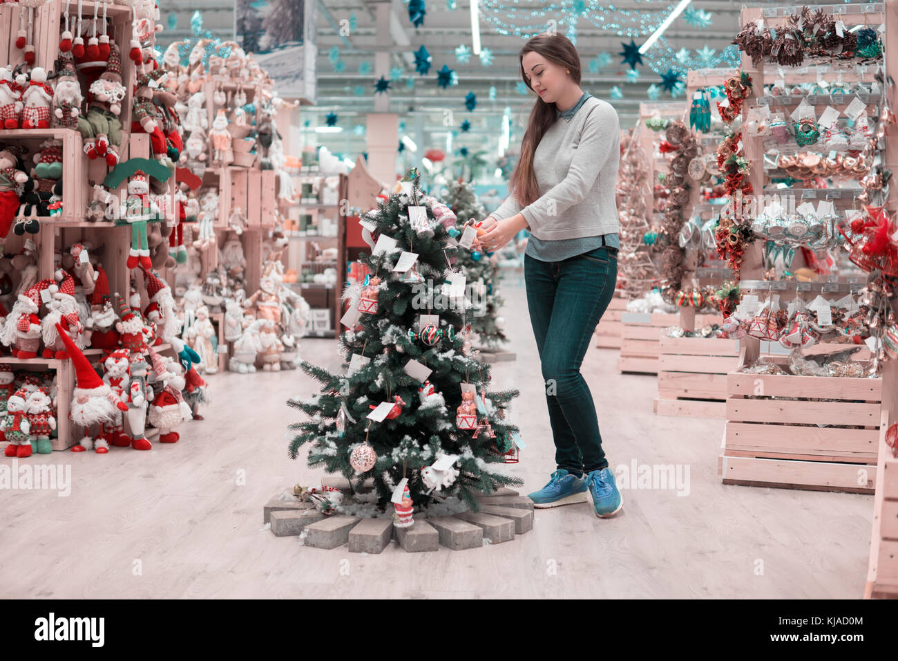 happy customer girl choosing Christmas tree for the new year Stock Photo