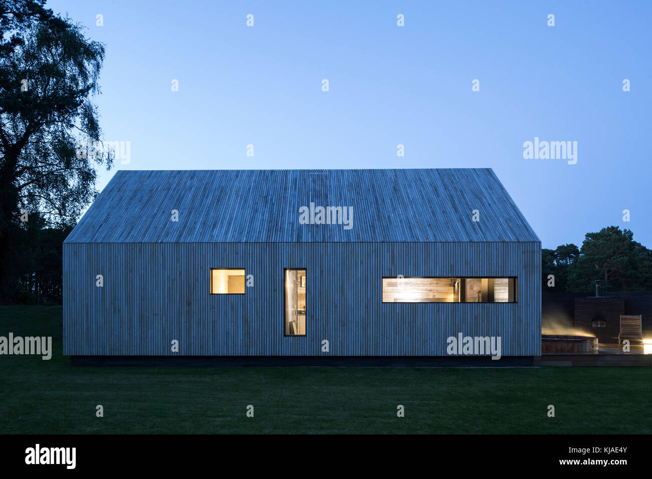 View of front facade at dusk. Watson House Annexe, Brockenhurst, United Kingdom. Architect: Strom Architects, 2017. Stock Photo