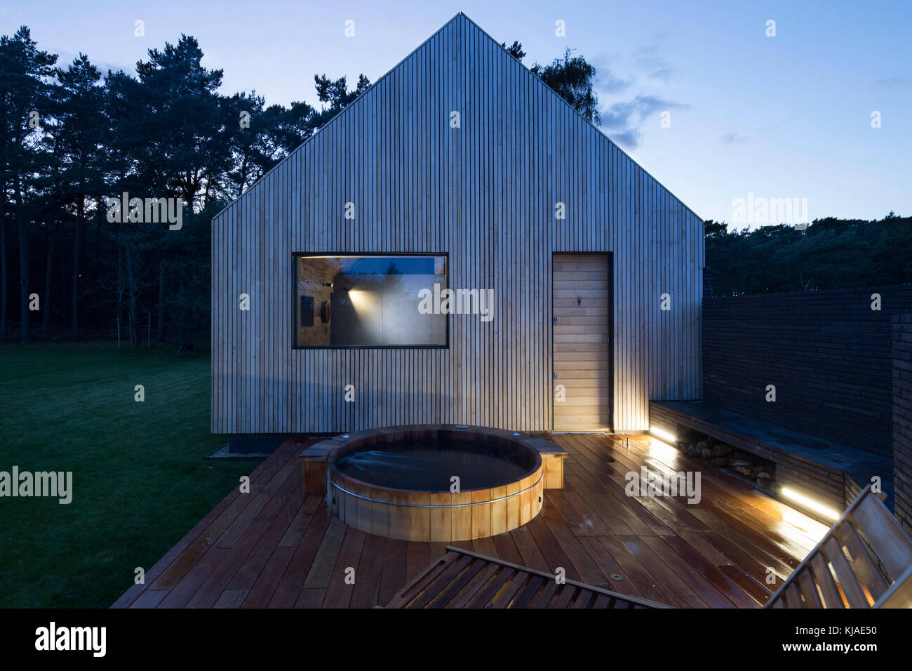 View of east facade at dusk. Watson House Annexe, Brockenhurst, United Kingdom. Architect: Strom Architects, 2017. Stock Photo