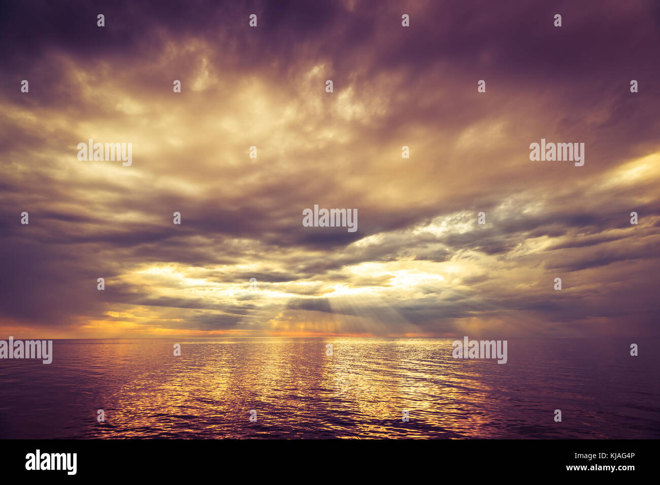 Dramatic ocean sunset with stormy clouds rain and sun rays Stock Photo ...