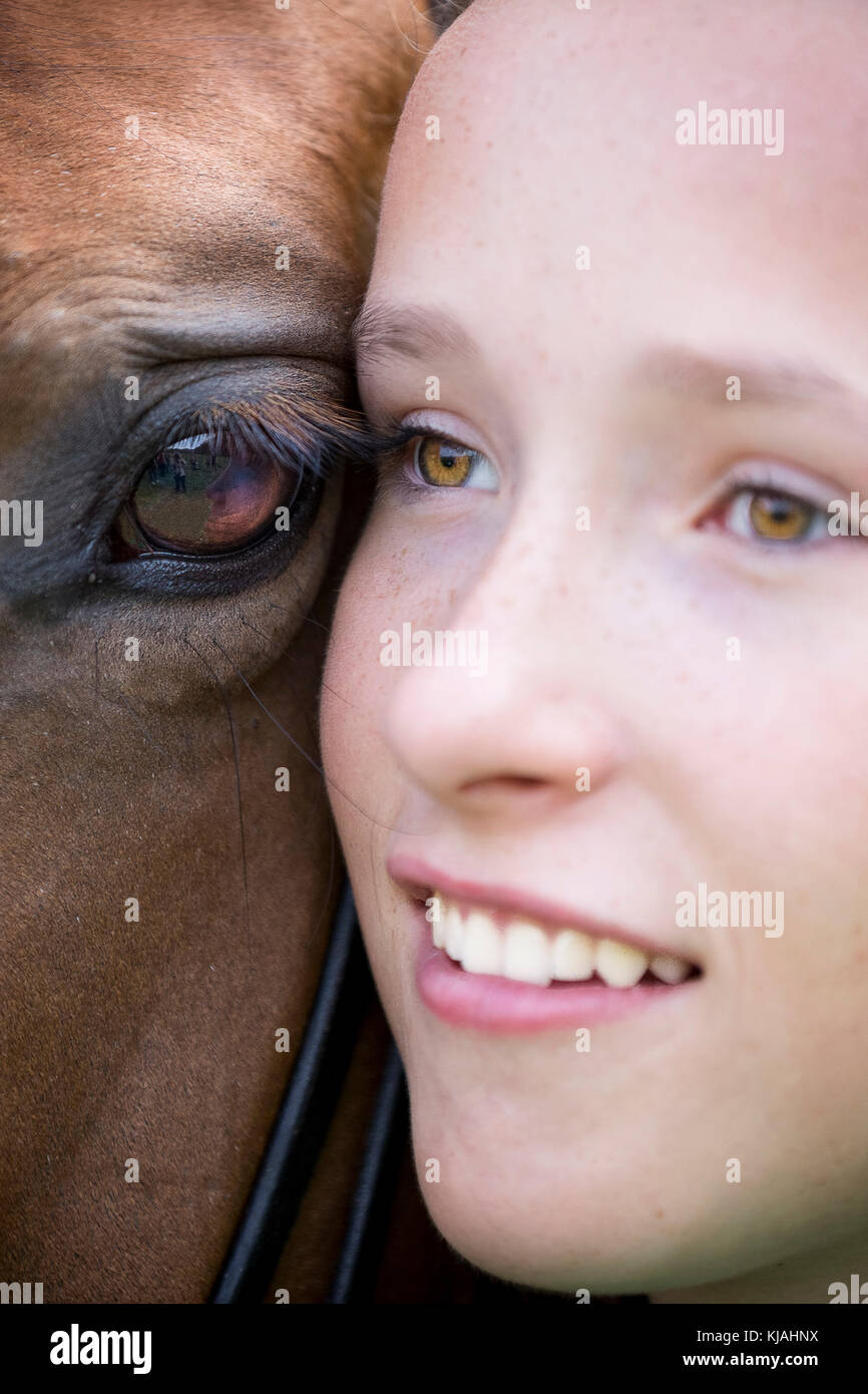 Trakehner. Girl cheek to cheek with bay mare. Germany Stock Photo