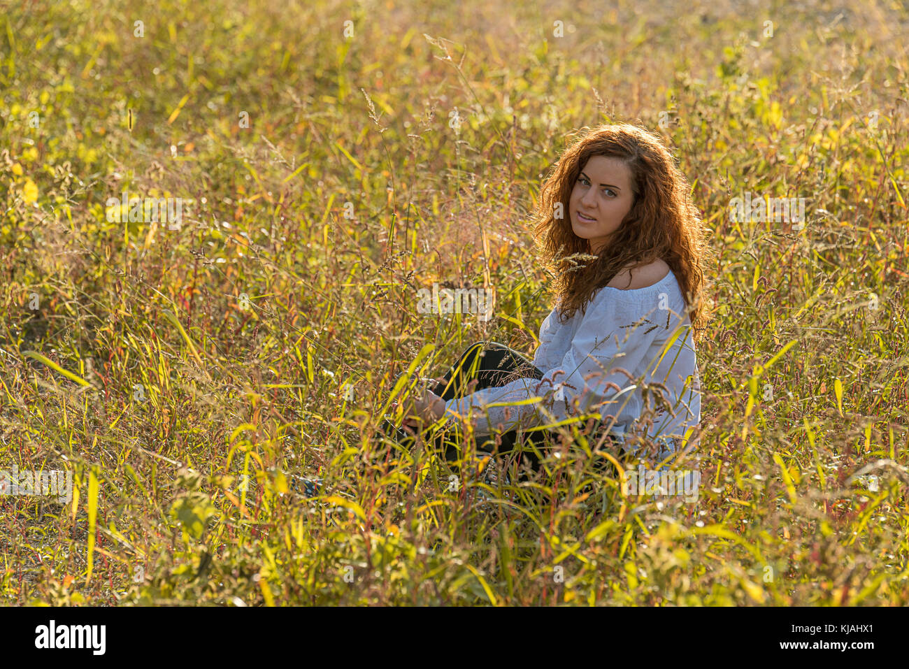 Girl with red hair in the grass Stock Photo - Alamy