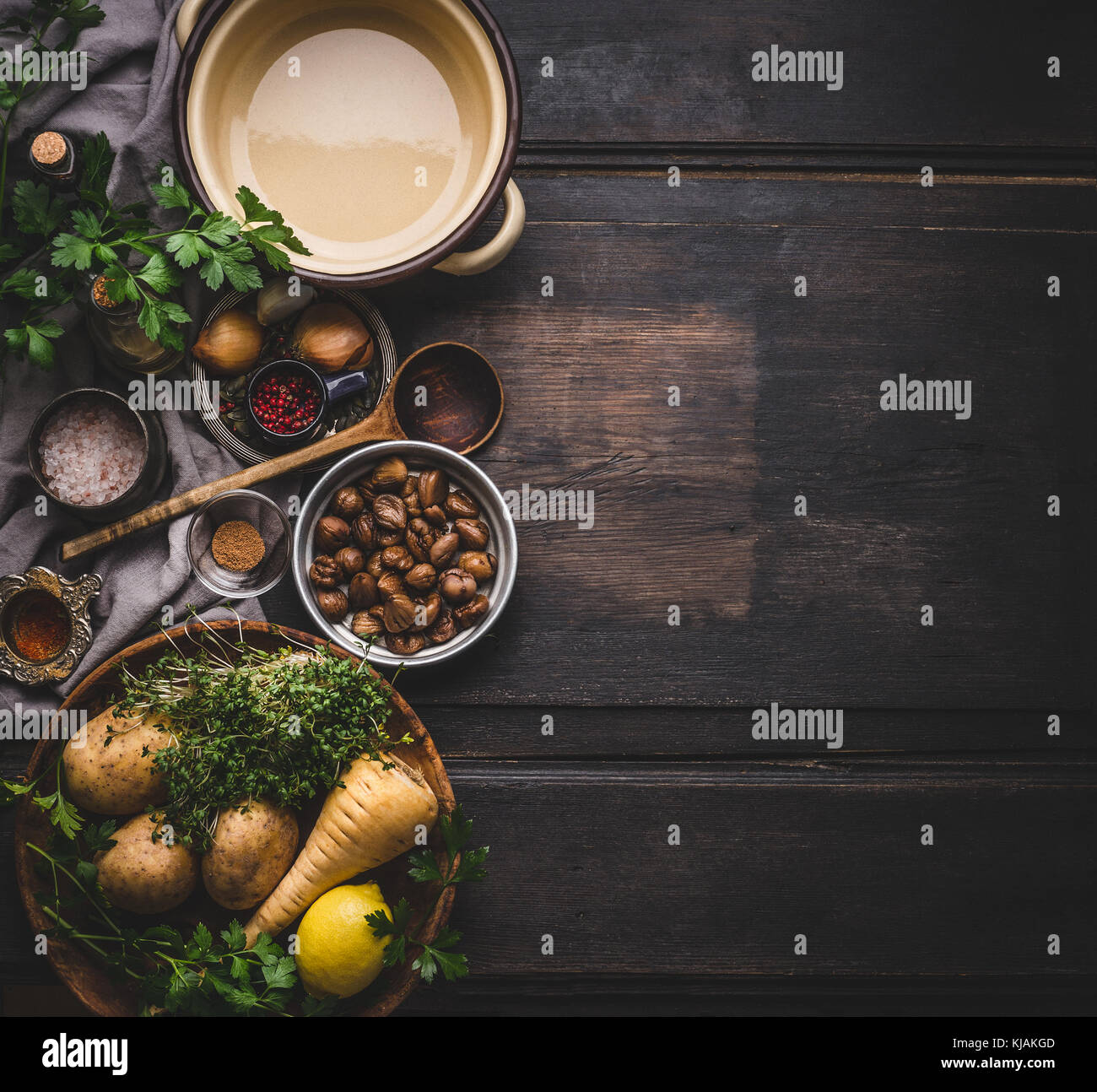Chestnuts soup cooking ingredients with pot and spoon on dark rustic background, top view, place for text. Seasonal food and eating Stock Photo