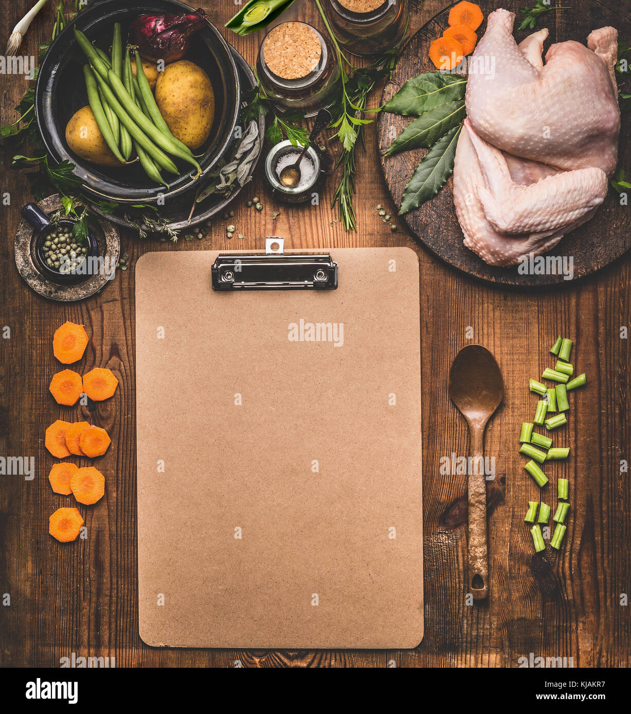 Chicken dishes cooking recipes background with empty cardboard clipboard  Whole chicken with various healthy cooking ingredients: chopped vegetables Stock Photo