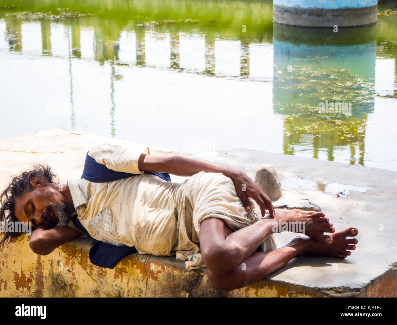 sleeping poor man - hindu bagger at the lake - old Udaipur Rajastan India Stock Photo