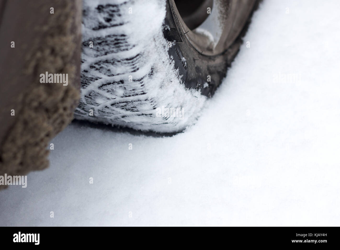 Car wheel on snowy road . Stock Photo