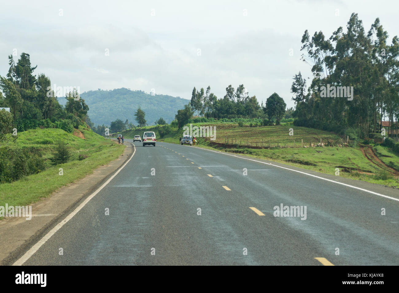 A countryside road with vehicles and people on it, Kenya, East Africa Stock Photo
