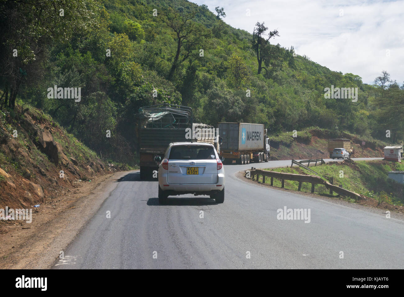 Trucks and other vehicles driving on main road through the Rift Valley escarpment, Kenya, East Africa Stock Photo