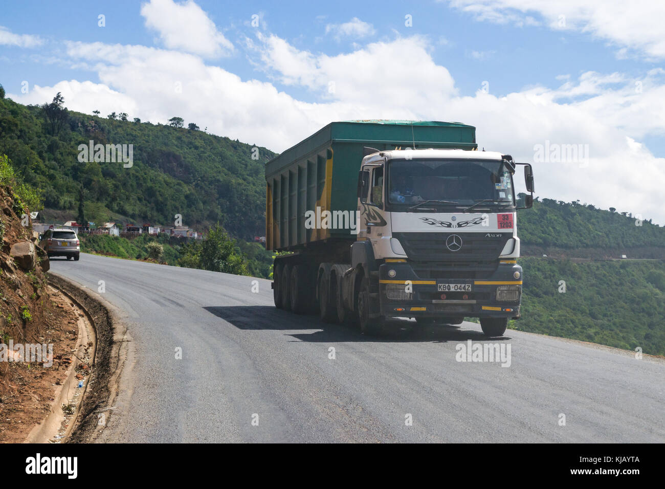 Trucks and other vehicles driving on main road through the Rift Valley escarpment, Kenya, East Africa Stock Photo