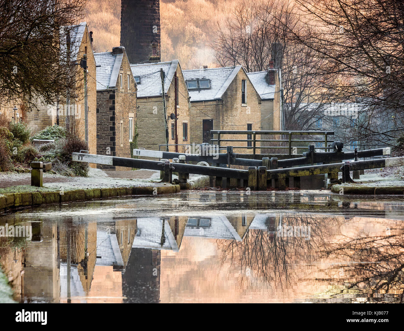 terraced houses reflected in still canal water at a set of locks on the rochdale canal at hebden bridge in calderdale west yorkshire Stock Photo