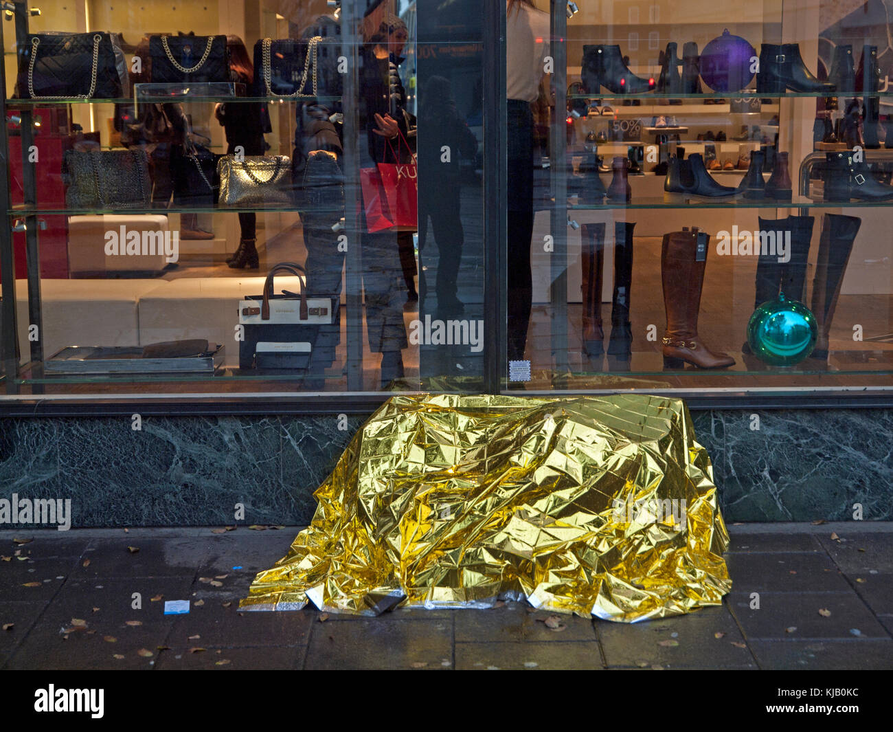 A homeless person's possessions hidden beneath gold wrapping paper on a Brighton street Stock Photo