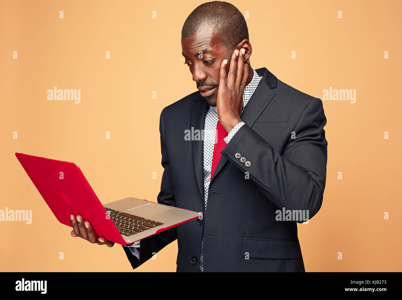 Handsome Afro American man sitting and using a laptop Stock Photo - Alamy