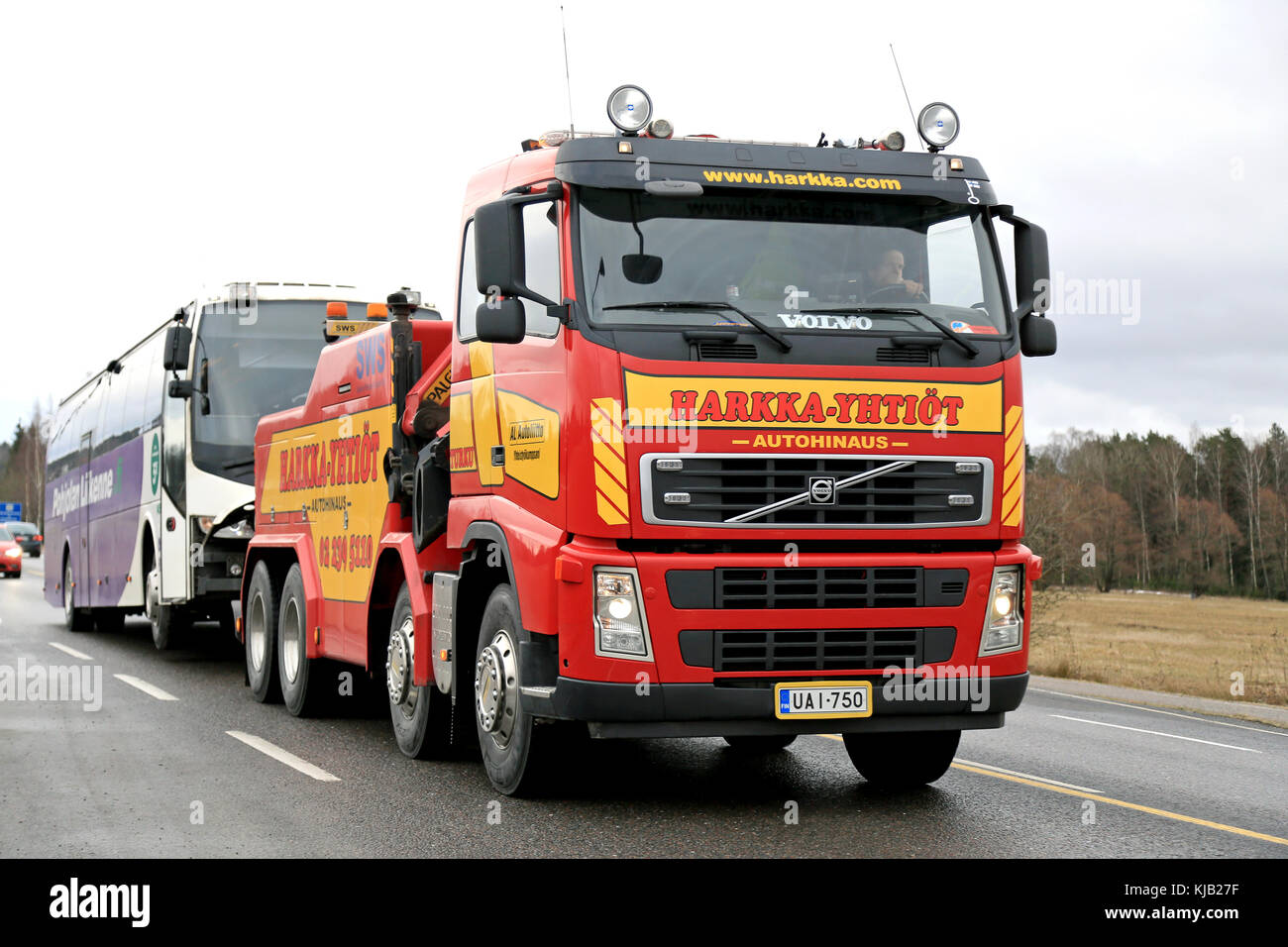 SALO, FINLAND - FEBRUARY 22, 2015: Volvo FH13 heavy duty tow truck tows a coach bus along highway 110. Due to the required skills and equipment, only  Stock Photo