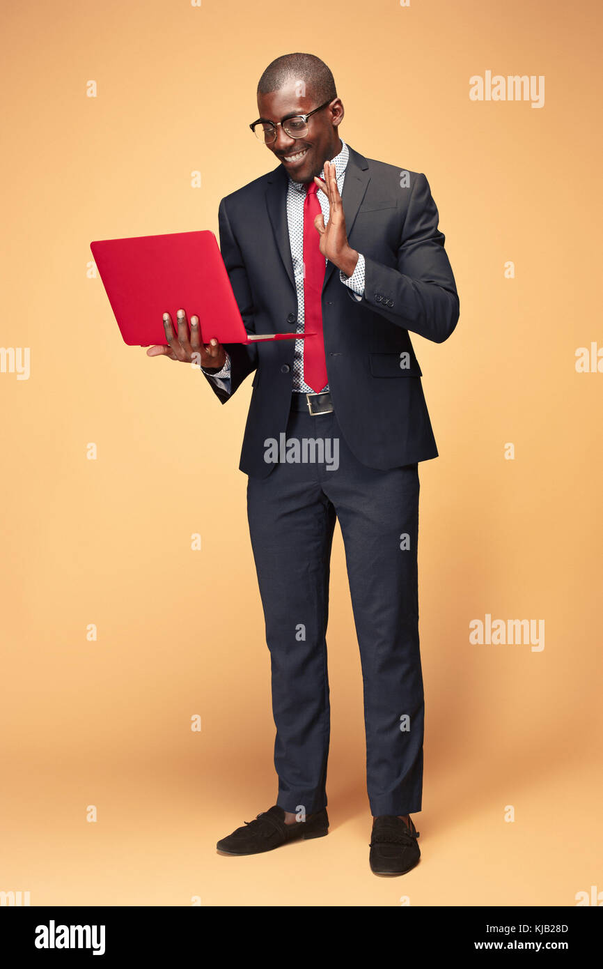 Handsome Afro American man sitting and using a laptop Stock Photo - Alamy